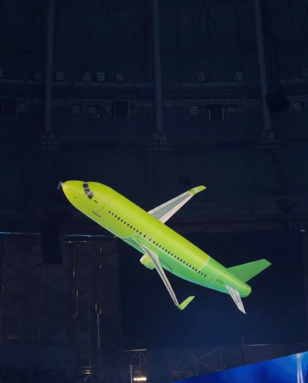 Radio-controlled airliner model flying indoors at an event